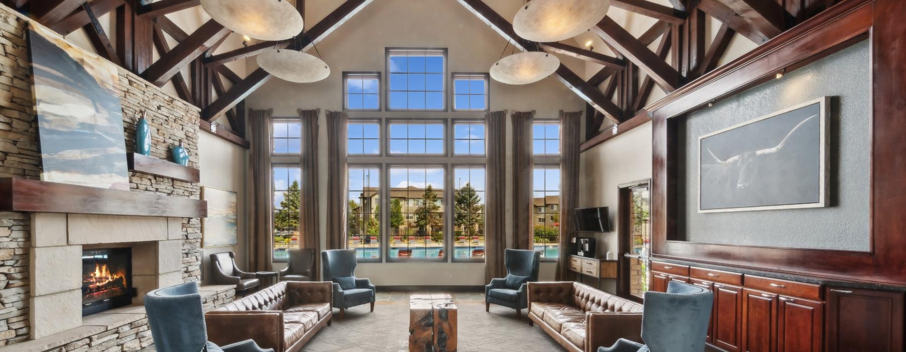 a clubhouse room with a fireplace and chairs